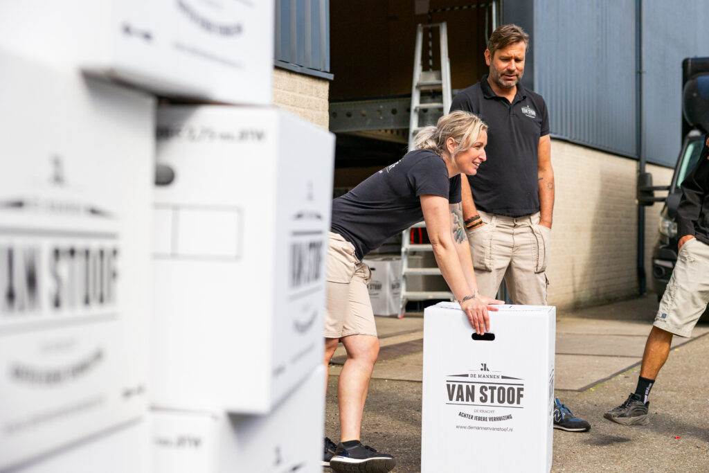Verhuizer van De Mannen van Stoof tilt een verhuisdoos bij de bedrijfsruimte